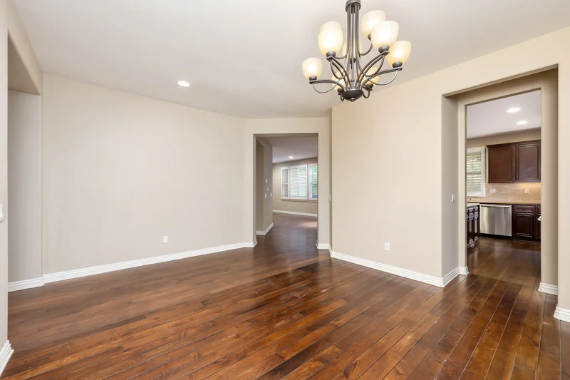 Freshly painted beige interior walls with polished hardwood floors and chandelier Freshly painted beige interior walls with polished hardwood floors and chandelier