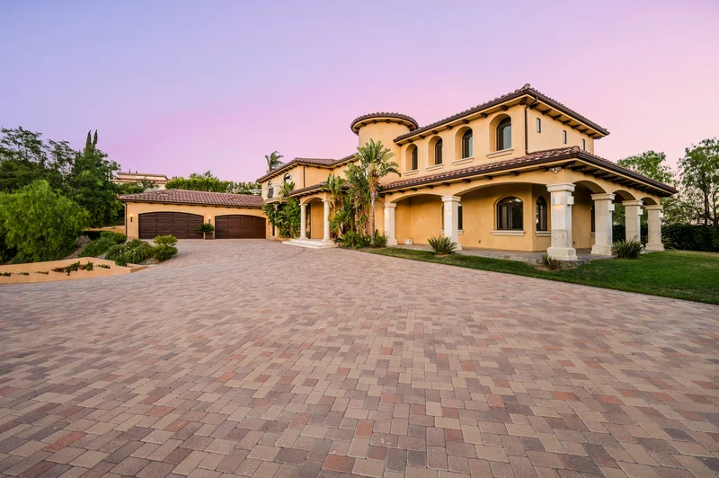 Mediterranean villa exterior paint job with paved driveway under twilight sky Mediterranean villa exterior paint job with paved driveway under twilight sky